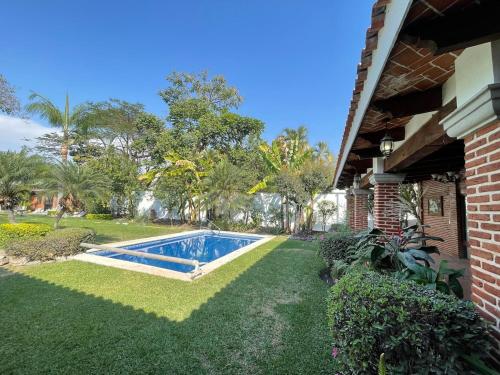 a swimming pool in a yard next to a house at Casa Colibri, residencia de descanso in Xochitepec