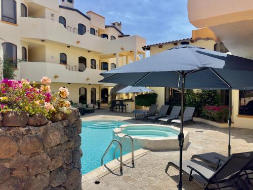 a pool with chairs and an umbrella next to a building at Rosarito Puerto Nuevo Surf 1BR casita and pool in Raulis
