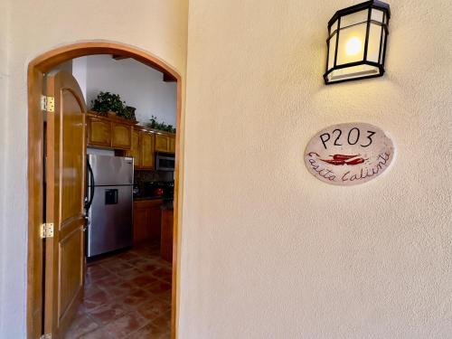 a kitchen with a sign on a wall with a door at Rosarito Puerto Nuevo Surf 1BR casita and pool in Raulis