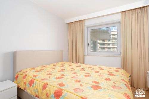 a bedroom with a bed and a window at Europan A0502 Esplanade, stijlvol en vlakbij het strand in De Panne