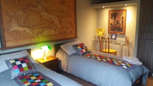 サンティアゴにあるApartopのベッドルーム1室(ベッド2台付)が備わります。壁には絵画が飾られています。