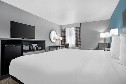 a hotel room with a large bed and a flat screen tv at Best Western Brewton Inn in Brewton