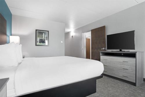 a white bedroom with a large bed and a flat screen tv at Best Western Brewton Inn in Brewton
