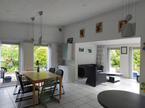 a kitchen and dining room with a table and chairs at Summer house on quiet park close to beach in Ouddorp