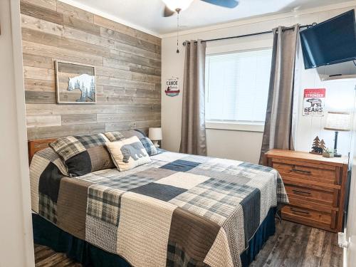 a bedroom with a bed and a wooden wall at Beechview Condo in Beech Mountain