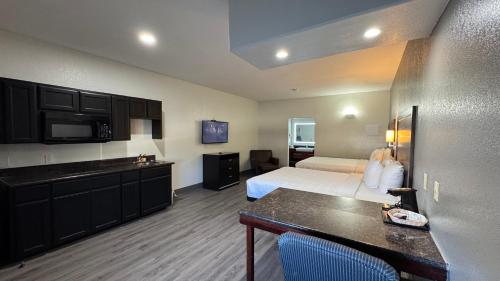 a hotel room with a bed and a kitchen at Sunbridge Inn & Suite Extended Stay in Jourdanton