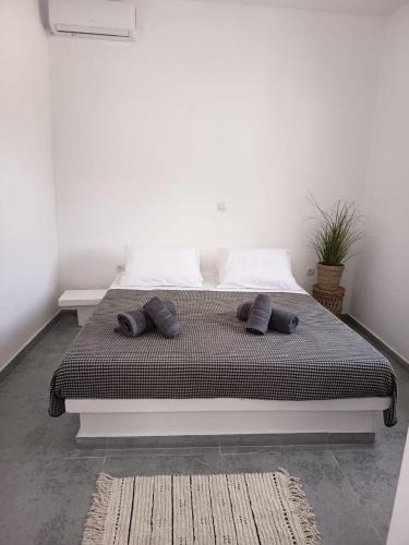 a bed with two pillows on it in a room at Lefkes Beach Suite in Kithnos