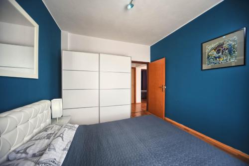 a bedroom with a bed and a blue wall at Apartments Villa Excellente Belvedere in Pula