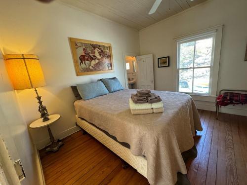 une chambre avec un lit, une lampe et une fenêtre dans l'établissement The Bisbee Yacht Club, à Bisbee