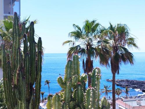 a group of palm trees and the ocean at Sol del Sur Ocean View in Puerto de Santiago