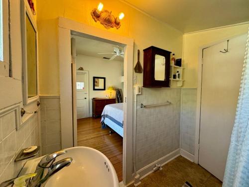 une salle de bain avec un lavabo et une chambre avec un lit dans l'établissement The Bisbee Yacht Club, à Bisbee