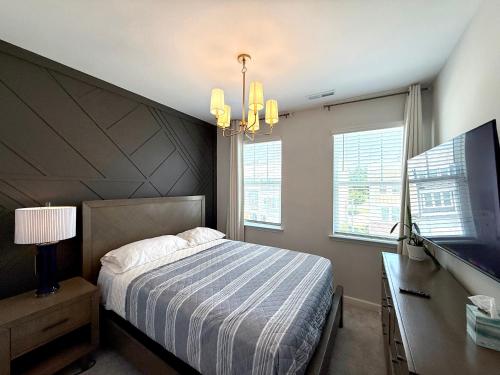 a bedroom with a bed and a desk and a television at The Villas The One Villa by RDU Airport with Indoor Heated Pool and Gym in Durham