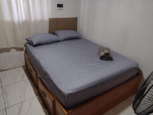 a bed with a pair of shoes sitting on it at Casa com 2 quartos in Rio das Ostras