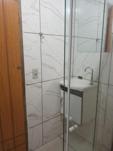a bathroom with a sink and a glass shower at Casa com 2 quartos in Rio das Ostras