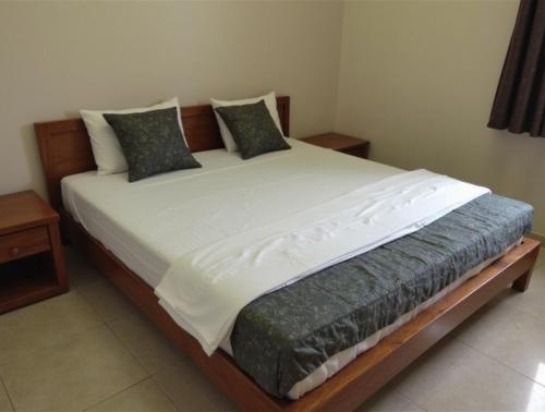 a large bed in a room with two tables at Sewwandi Guest House in Arugam Bay