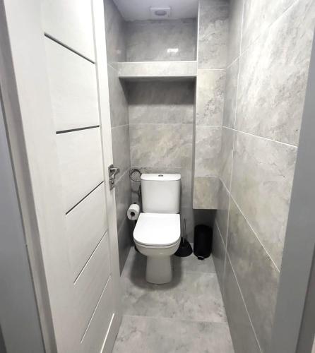 a small bathroom with a toilet and a door at Apartman Yasmin Drienica in Drienica