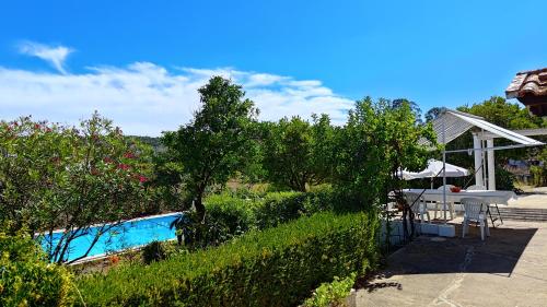 a backyard with a pool and a table and an umbrella at Casa do Campo com Piscina no Alentejo in Quinta de Sancha Cabeça