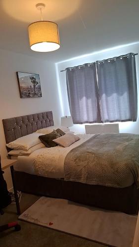 a bedroom with a large bed and a window at Tradewinds Integrated Services Ltd in Peterborough