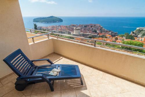 una silla azul sentada en un balcón con vistas en Apartments Simic en Dubrovnik