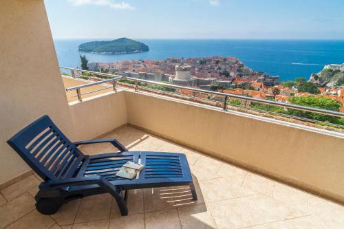 una silla azul sentada en un balcón con vistas en Apartments Simic, en Dubrovnik