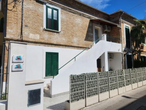ein Haus mit weißen Wänden und grünen Fensterläden in der Unterkunft Casa vacanze Nonna Anna in Montesilvano