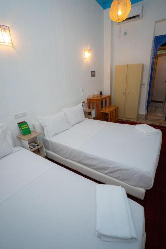 zwei Betten in einem Zimmer mit weißen Laken in der Unterkunft Studio Blue Majorelle Marrakech in Marrakesch