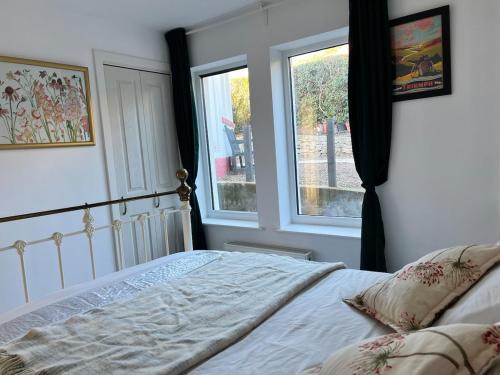 a bedroom with a bed and a window at Self-contained ground level cottage with hill view in Edinburgh