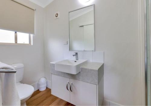 a white bathroom with a sink and a toilet at Darwin FreeSpirit Resort in Darwin