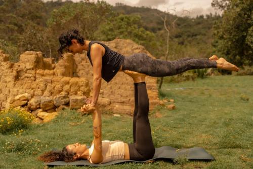 a woman laying on the ground with a man doing a yoga pose at Hotel Casa Selvaggio in Ráquira