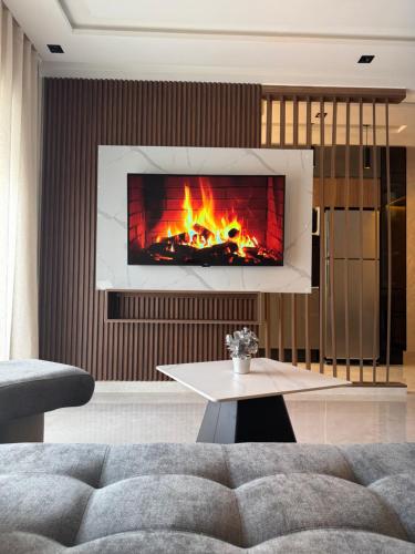 a living room with a fire in a fireplace at Appartement Luxueux Mer & Piscine in Mansouria