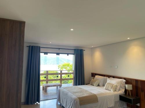 a bedroom with a large bed and a balcony at Maluhia Ilhabela 5 in Ilhabela
