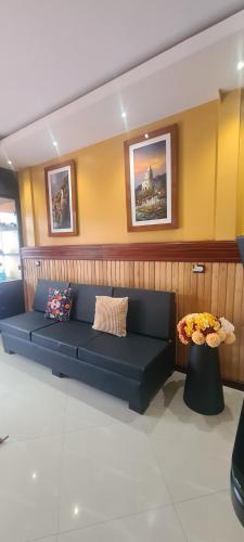 a blue couch in a room with paintings on the wall at Hotel California by Chat Noir in Cuenca