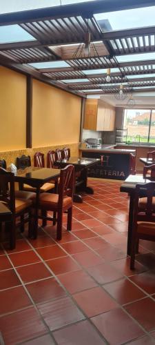 a restaurant with tables and chairs and a kitchen at Hotel California by Chat Noir in Cuenca