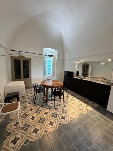 a dining room with a table and chairs on a floor at IL CARRUBO La dimora in Monopoli