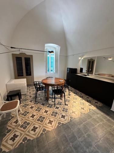 a room with a table and chairs on a floor at IL CARRUBO La dimora in Monopoli