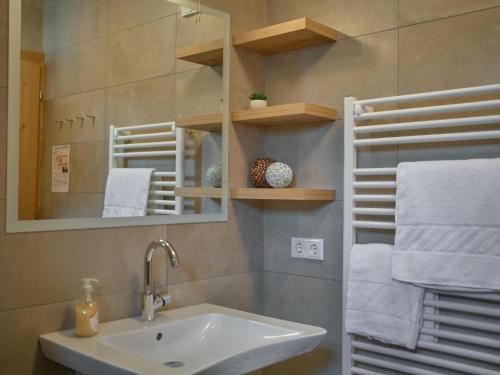 a bathroom with a sink and a mirror and towels at BergbiberHAUS Top A in Piesendorf