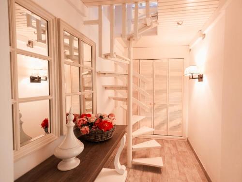 a staircase in a room with a vase and flowers at Lessix in Saint-Peïre-sur-Mer