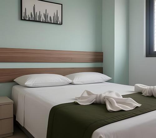 a bedroom with a large bed with white sheets at Resort beira-mar Porto Galinhas in Porto De Galinhas