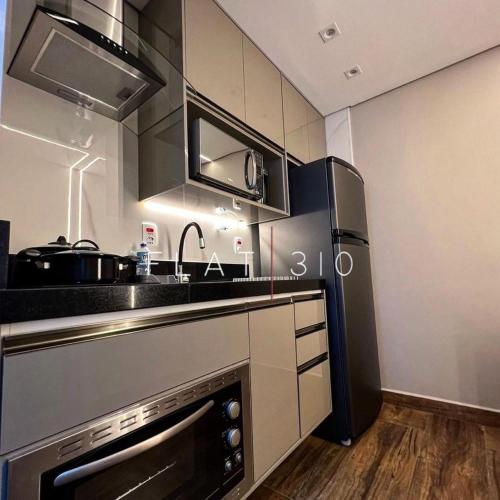 a kitchen with a stove and a refrigerator at Flat 310 A in São Vicente