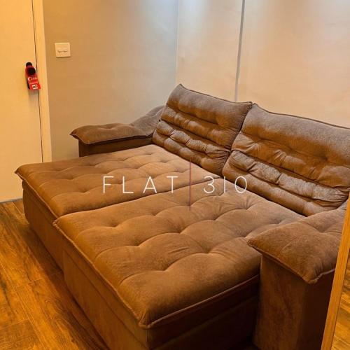 a brown leather couch sitting in a room at Flat 310 A in São Vicente