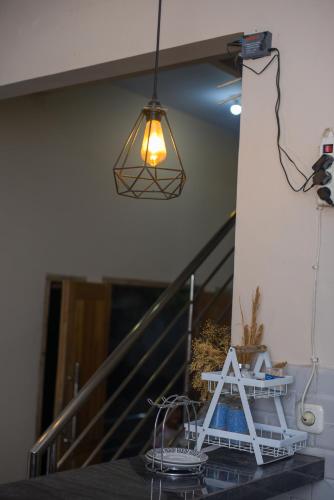 a light hanging over a table with a stair case at Tafufu Villa Tumpak Sewu in Sumberbopong