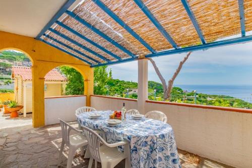 a table on a balcony with a view of the ocean at Tra il Borgo e il Mare - Bel Horizonte in Capoliveri