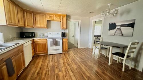 a kitchen with wooden cabinets and a table and a table and chairs at Hurricane Homestead Rentals in Hurricane