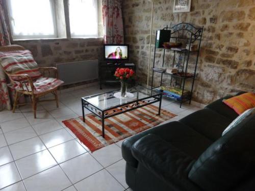 a living room with a couch and a coffee table at Gîte authentique avec terrasse, jardin, proche thermes et nature - FR-1-589-212 in Senaide