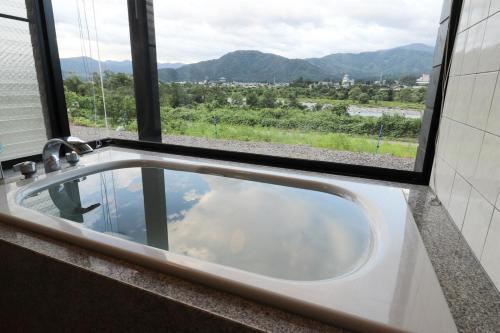 a bathroom sink with a view of the mountains at 勝山四季の宿 清流亭 一棟貸で周囲500メートルに民家なし in Katsuyama
