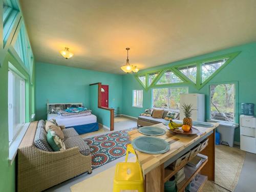 a living room with a table and a room with a bed at Best Ocean Views from Guesthouse in Hawaiian Ocean View Estates