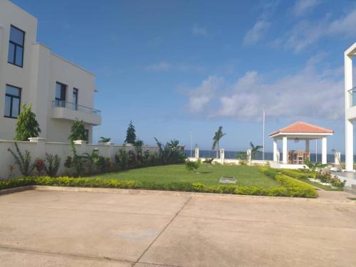 a large white building with a yard next to a building at Fumba Uptown Ocean Front Villa in Fumba Uwandani