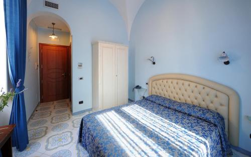 ein Schlafzimmer mit einem Bett in einem blauen Zimmer in der Unterkunft B&B Palazzo Pisani in Amalfi