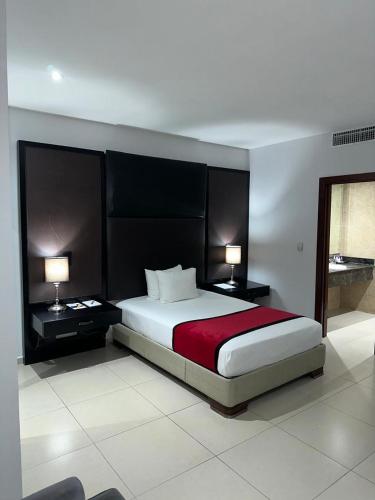 une chambre avec un grand lit avec deux lampes dans l'établissement Ramada by Wyndham Princess Santo Domingo, à Saint-Domingue