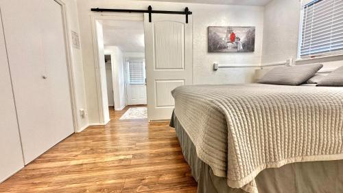 a bedroom with a bed and a wooden floor at Hurricane Homestead Rentals in Hurricane